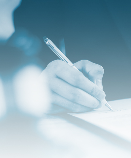 A business professional signing an important document with a pen, showcasing a moment of decision-making and commitment.